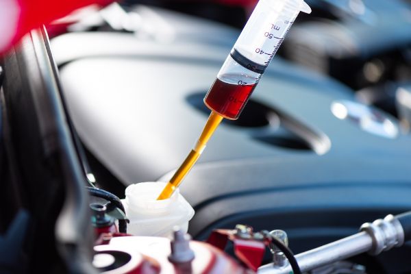 Technician doing a Fluid Flush on a vehicle. Vehicle maintenance concept