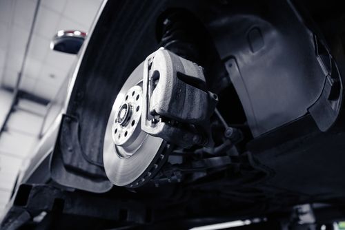 Closeup of steel brake disc in car service.