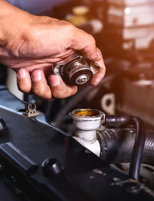 Mechanic opening a radiator cap to check the coolant