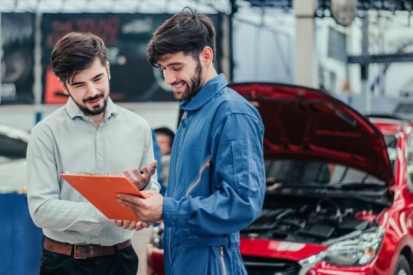mechanic assisting a customer for a vehicle maintenance inspection